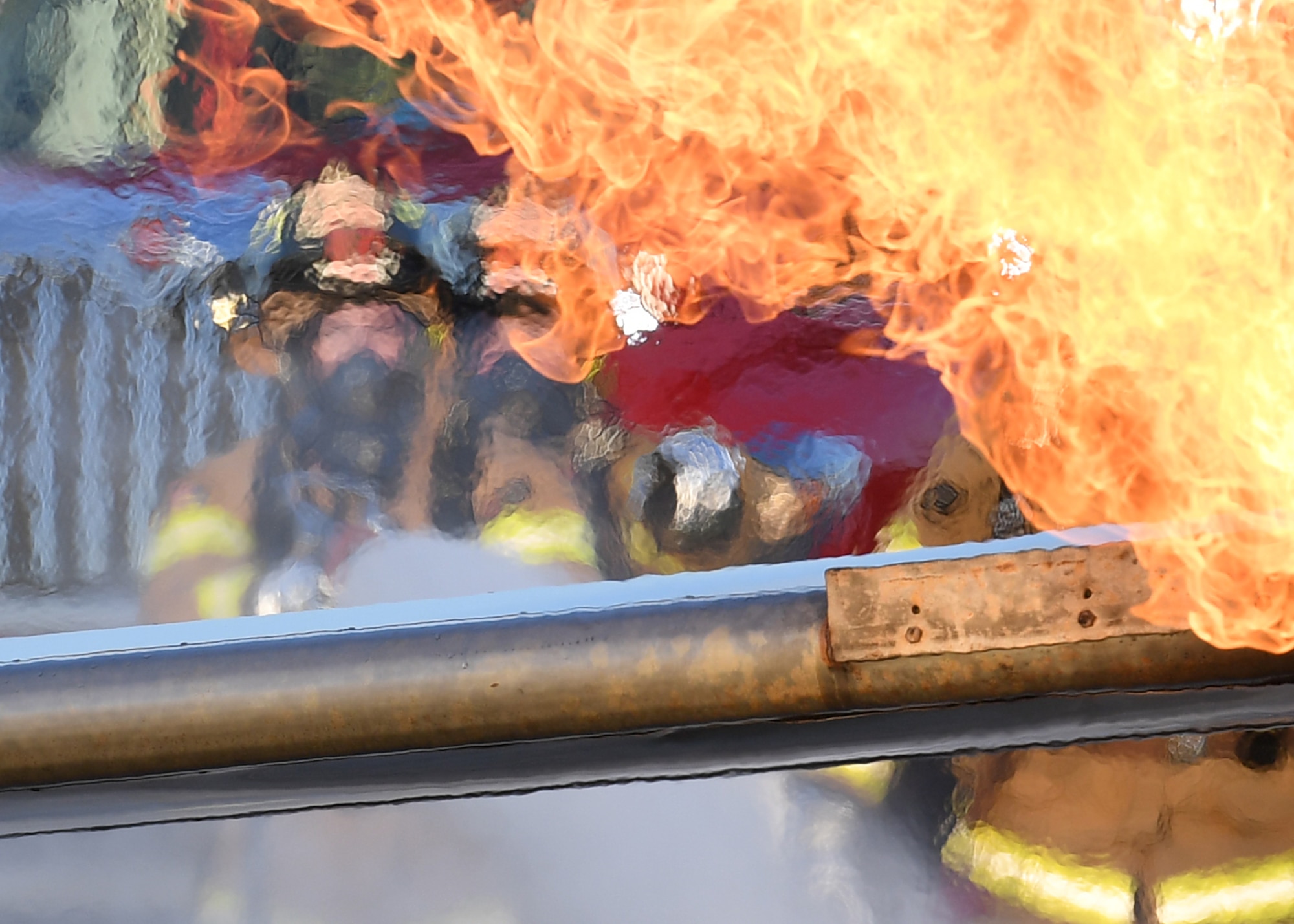 Keesler firefighters use a hand-held hose to extinguish a fire on a mock C-123 training device during an aircraft rescue fire fighting training on Keesler Air Force Base, Mississippi, June 4, 2019. The joint agency training allowed the Keesler Fire Department, Gulfport Combat Readiness Training Center Fire Department, Stennis Airport Fire Department and the U.S. Naval Air Station Pensacola Gulf Coast Fire Rescue to meet the semi-annual training requirement to practice aircraft rescue and live fire training evolutions. (U.S. Air Force photo by Kemberly Groue)