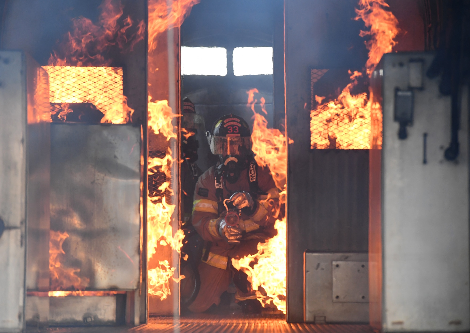 A Keesler firefighter uses a hand-held hose to extinguish a fire inside a mock C-123 training device during an aircraft rescue fire fighting training on Keesler Air Force Base, Mississippi, June 4, 2019. The joint agency training allowed the Keesler Fire Department, Gulfport Combat Readiness Training Center Fire Department, Stennis Airport Fire Department and the U.S. Naval Air Station Pensacola Gulf Coast Fire Rescue to meet the semi-annual training requirement to practice aircraft rescue and live fire training evolutions. (U.S. Air Force photo by Kemberly Groue)