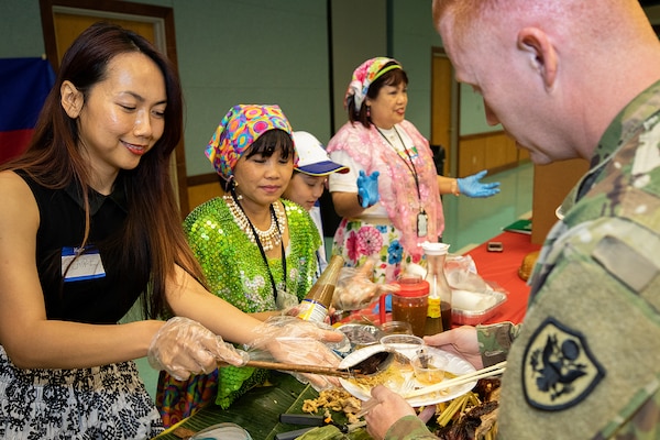 Claire Hoang, Defense Finance and Accounting Service financial management analyst, left, and Josie Swinarski, a local caterer, serve U.S. Army Sgt. Timothy Holloman, 326th Financial Management Support Center military pay technician currently assigned to the Defense Finance and Accounting Service, during an Asian American Pacific Heritage event at the Maj. Gen. Emmett J. Bean Center here June 4, 2019. The U.S. Army Financial Management Command and DFAS teamed up to host the event meant to showcase Asian and Pacific Islander heritage, whit this year’s event focused specifically on South Korea and the Philippines.