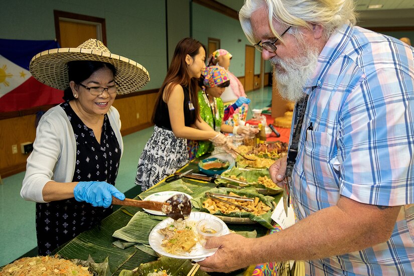 Ma Anita Ward, a Defense Finance and Accounting Service accounts maintenance clerk, serves food to James A. Healy III, U.S. Army Financial Management Command human resources specialist during an Asian American Pacific Heritage event at the Maj. Gen. Emmett J. Bean Center here June 4, 2019. USAFMCOM and DFAS teamed up to host the event meant to showcase Asian and Pacific Islander heritage, whit this year’s event focused specifically on South Korea and the Philippines.
