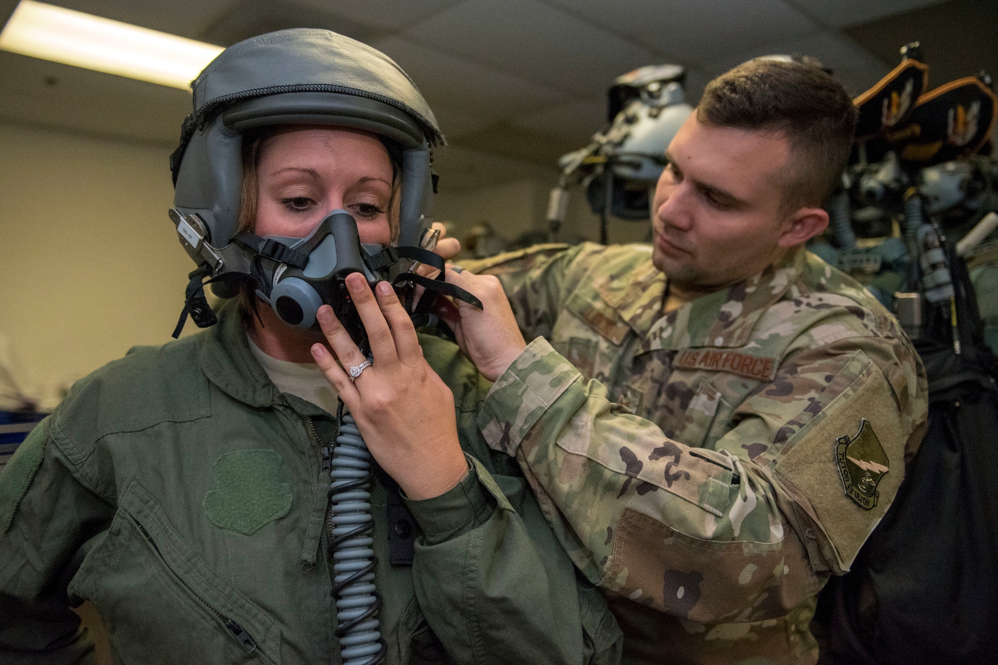 Staff Sgt. Daniel Locke, 314th Fighter Squadron Aircrew Flight Equipment technician, fits a helment to Staff Sgt. Saydee Osborn, 49th Equipment Maintenance Squadron Non-Destructive Inspection technician June 4, 2019, on Marine Corps Air Station Miramar, Calif. Airmen from the 314th FS and 314th Aircraft Maintenance Unit had the opportunity to take a familiarization flight in a 314th FS F-16 Viper to experience dissimiliar combat air training alongside F/A-18 Hornets from the Marine Fighter Attack Squadron 314. (U.S. Air Force photo by Staff Sgt. Christine Groening)