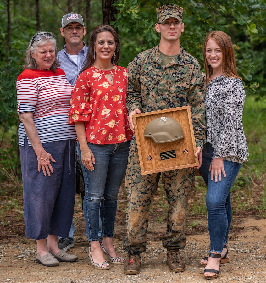 Cpl. Nicholas DeSantis-Austin, second from left, team leader with 3rd Battalion, 23rd Marine Regiment, poses with family members after his Kevlar Helmet Return ceremony at Fort Benning, Ga., June 9, 2019.  On Aug. 4, 2018, during the execution of Operation Gladius Nolay, aboard the Afghan Army Camp Nolay in Sangin District, Afghanistan, DeSantis-Austin was struck in the helmet by enemy sniper fire while providing security on a rooftop post. Afterwards, he received the prestigious Purple Heart award and Combat Action Ribbon for his heroic actions. (Marine Corps Photo by Cpl. Daniel R. Betancourt Jr.)