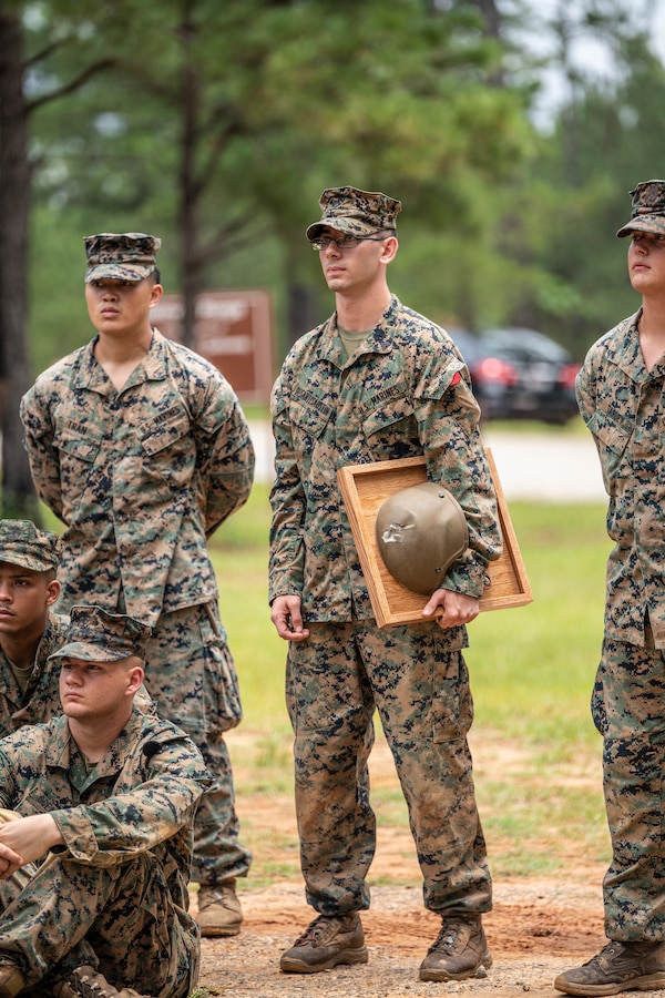 Cpl. Nicholas DeSantis-Austin, center, team leader with 3rd Battalion, 23rd Marine Regiment, stands amongst his peers after his Kevlar Helmet Return ceremony at Fort Benning, Ga., June 9, 2019.  On Aug. 4, 2018, during the execution of Operation Gladius Nolay, aboard the Afghan Army Camp Nolay in Sangin District, Afghanistan, DeSantis-Austin was struck in the helmet by enemy sniper fire while providing security on a rooftop post. Afterwards, he received the prestigious Purple Heart award and Combat Action Ribbon for his heroic actions. (Marine Corps Photo by Cpl. Daniel R. Betancourt Jr.)