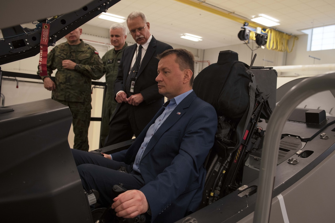 A man sits in the cockpit of an aircraft trainer.