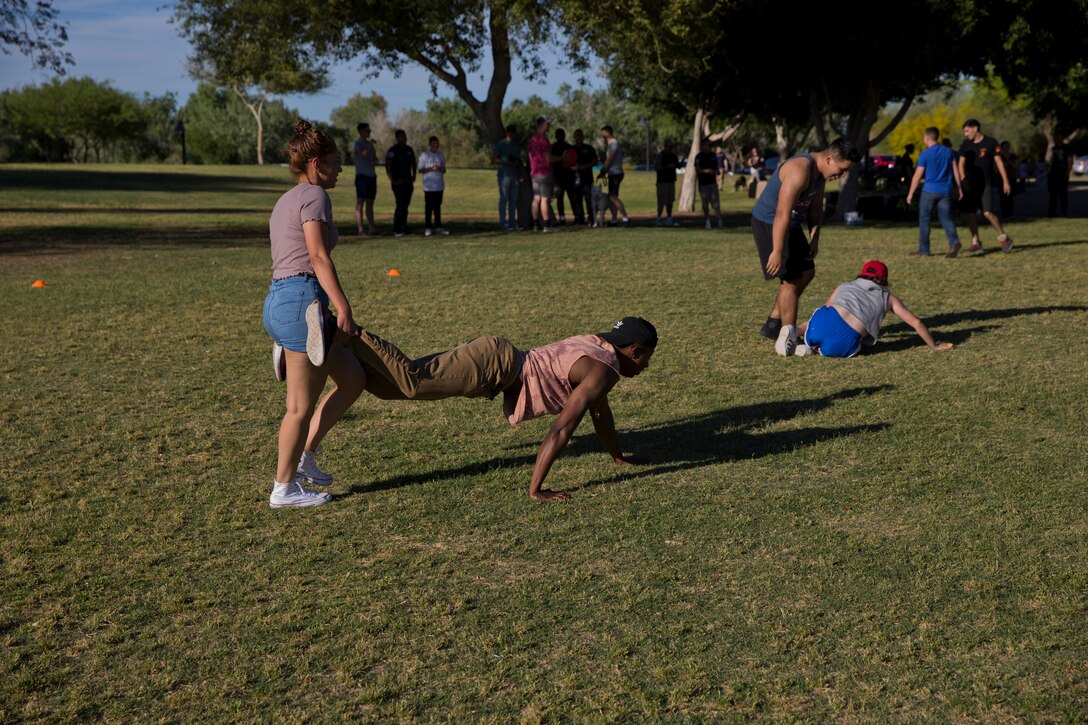 U.S. Marines and Sailors assigned to Headquarters and Headquarters Squadron (H&HS) race towards the finish line during the H&HS Family Day cardboard boat race at West Wetlands Park Yuma Ariz., April 18, 2019. (U.S. Marine Corps photo by Lance Cpl. Joel Soriano)
