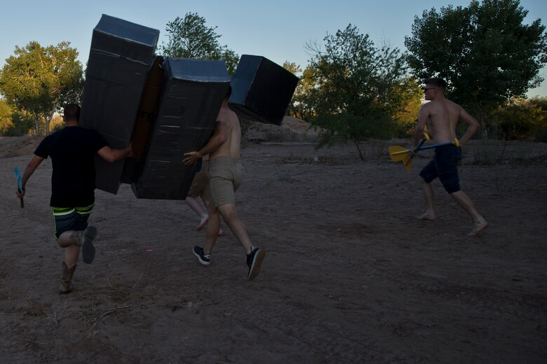 U.S. Marines and Sailors assigned to Headquarters and Headquarters Squadron (H&HS) race towards the finish line during the H&HS Family Day cardboard boat race at West Wetlands Park Yuma Ariz., April 18, 2019. (U.S. Marine Corps photo by Lance Cpl. Joel Soriano)