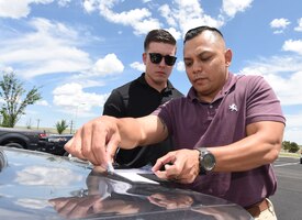John Camacho, 50th Security Force Squadron noncommissioned officer in charge of investigations, dusts a fine powder to capture fingerprint residue left on a vehicle as investigator Kyle Maldonado, 50th SFS investigator, observes at Schriever Air Force Base, Colorado, June 5, 2019. The investigation flight provides intelligence and conducts internal security crucial to protect the base’s mission and personnel. (U.S. Air Force photo by Staff Sgt. Matthew Coleman-Foster)