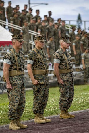 U.S. Marines and Sailors of 3rd MLG, stand at attention during the playing of Anchors Aweigh at a relief and appointment ceremony May 31, 2019, at Camp Kinser, Okinawa, Japan. Sgt. Maj. Kenneth A. Miller ceremoniously transferred accountability and authority of enlisted Marines to Sgt. Maj. John R. Preston during the ceremony. Miller, the outgoing regimental sergeant major of CLR-35, 3rd MLG, is a native of Woodland, California. Preston, the incoming regimental sergeant major of CLR-35, 3rd MLG, is a native of Easley, South Carolina. (U.S. Marine Corps photo by Lance Cpl. Terry Wong)