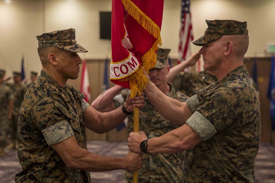 U.S. Marine Corps Col. Scott R. Johnson, passes the regimental colors to Col. Omar J. Randall during a change of command ceremony June 7, 2019, at Camp Kinser, Okinawa, Japan. Johnson, a native of Talkeetna, Alaska, relinquished command of Combat Logistics Regiment 37, 3rd Marine Logistics Group, to Randall, a native of Bronx, New York, during the ceremony. (U.S. Marine Corps photo by Lance Cpl. Terry Wong)