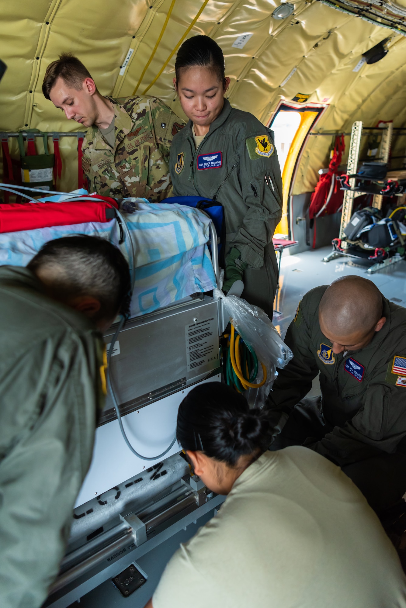 U.S. Air Force Staff Sgt. Bianca Alcantara, aeromedical evacuation technician assigned to the 18th Aeromedical Evacuation Squadron, lifts the neonatal transport system to be secured on the KC-135 Stratotanker during a Neonatal Intensive Care Unit transportation course June 5, 2019, on Kadena Air Base, Japan. The 18th Aerospace Medicine Squadron briefed the NICU nurses and technicians over the responsibilities of infant patient transportation on the ground, while the 18th AES focused on transportation while on the air. (U.S. Air Force photo by Airman 1st Class Cynthia Belío)