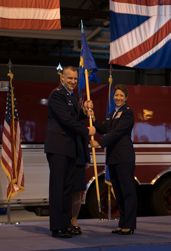 U.S. Air Force Col. Christopher Bromen, 423rd Air Base Group commander, hands the guidon to Lt. Col. Elizabeth Anne Louise Hoettels who assumes command of the 423rd Medical Squadron at RAF Alconbury, England, June 11, 2019. The Change of Command ceremony represents the official exchange of leadership. (U.S. Air Force photo by Airman 1st Class Gabrielle Winn)