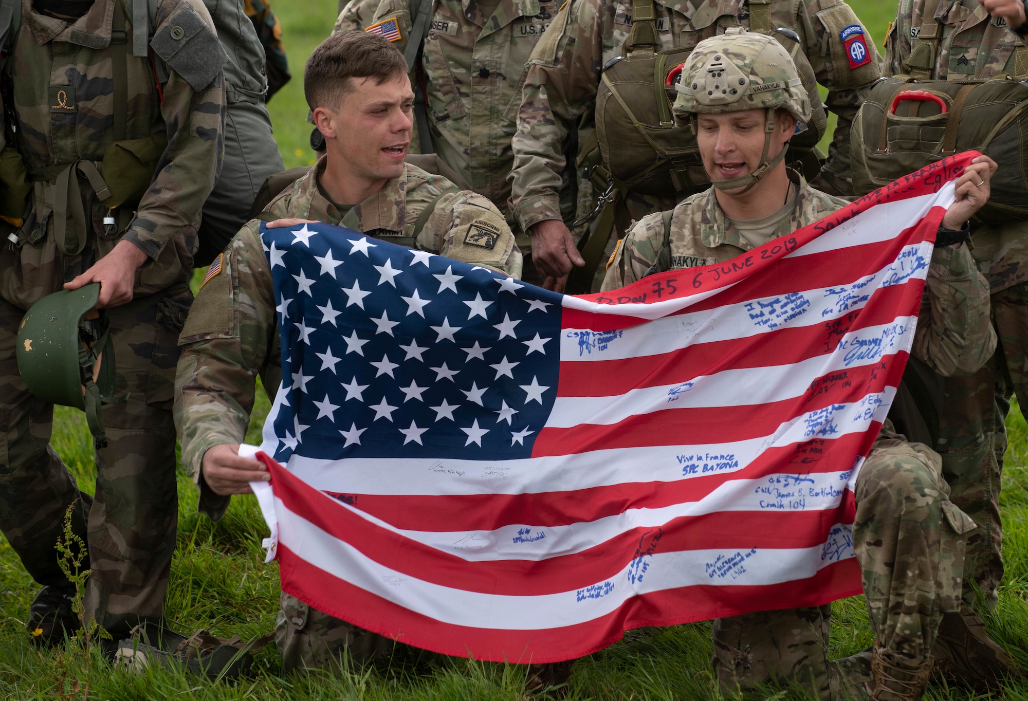 Service members hold the U.S flag after conducting a parachute jump during the D-Day 75 Commemorative Airborne Operation in Sainte-Mere-Eglise, France, June 9, 2019, which honors the epic airborne operation conducted by Allied forces on June 6, 1944. Seventy-five years later, the bravery and heroism by all allies during World War II continues to resonate with U.S. forces in Europe - who remain steadfast in their commitment to European allies and partners. (U.S. Air Force photo by Airman 1st Class Jennifer Zima)