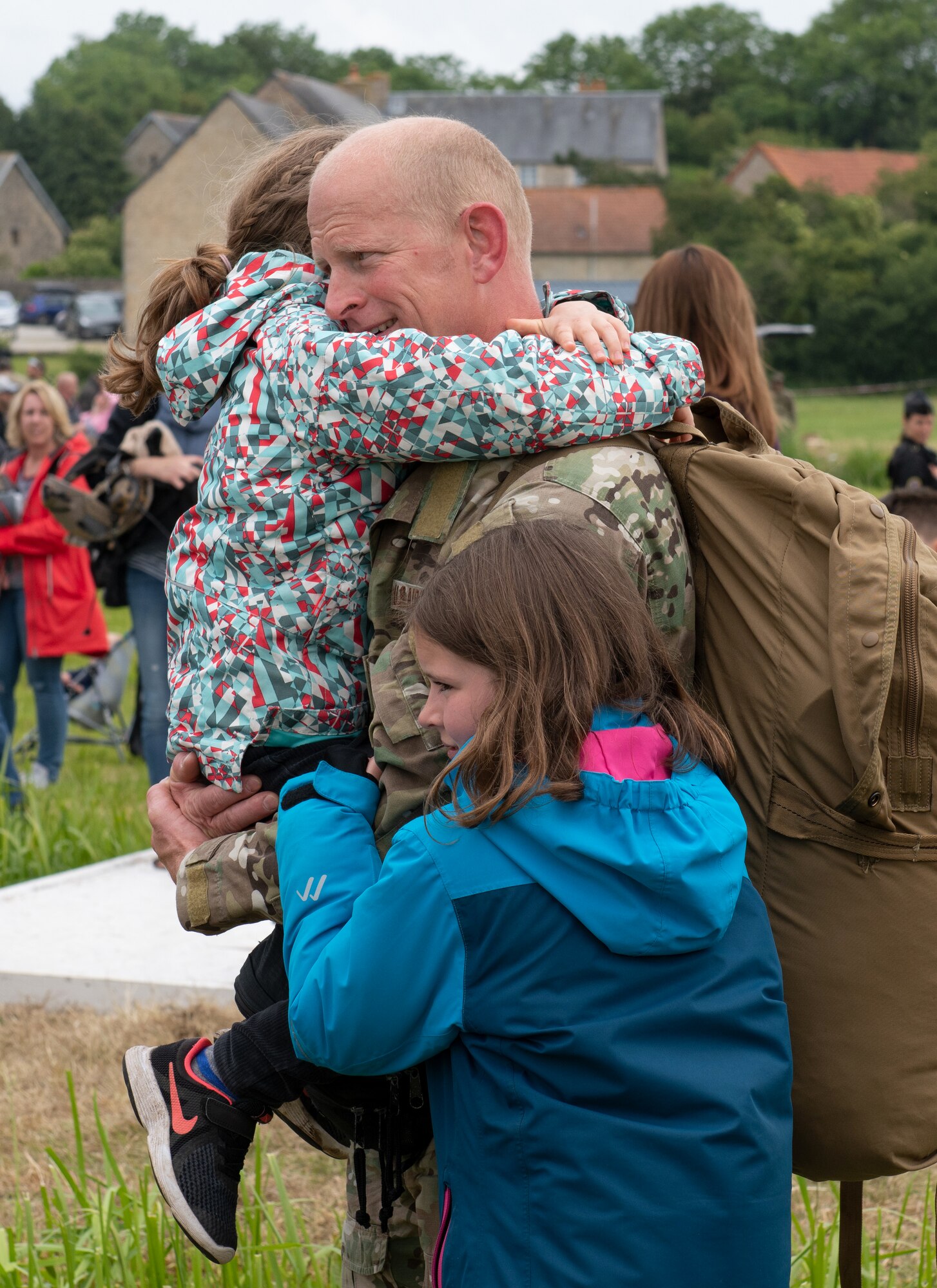 U.S. Air Force Lt. Col. Jake Miller, 752nd Special Operations Group deputy commander, embraces his daughters at the D-Day 75 Commemorative Airborne Operation in Sainte-Mere-Eglise, France, June 9, 2019. This commemorative airborne operation was an opportunity for multinational forces to honor the past and simultaneously work to secure the future. Training together in the very same place that trans-Atlantic resolve began 75 years ago demonstrates the partnerships and bonds that we highly value and continue to benefit from to this day. (U.S. Air Force photo by Airman 1st Class Jennifer Zima)