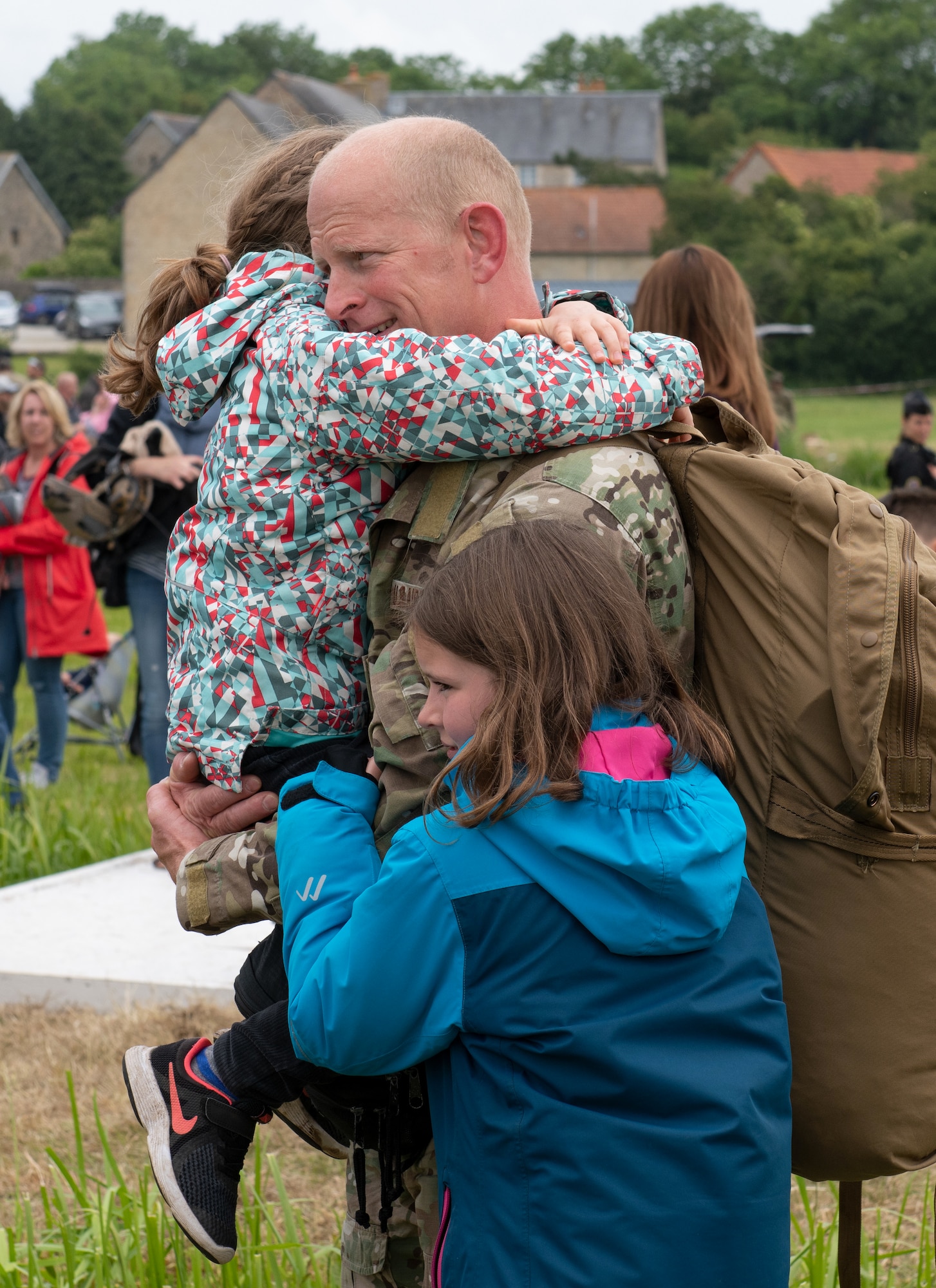 U.S. Air Force Lt. Col. Jake Miller, 752nd Special Operations Group deputy commander, embraces his daughters at the D-Day 75 Commemorative Airborne Operation in Sainte-Mere-Eglise, France, June 9, 2019. This commemorative airborne operation was an opportunity for multinational forces to honor the past and simultaneously work to secure the future. Training together in the very same place that trans-Atlantic resolve began 75 years ago demonstrates the partnerships and bonds that we highly value and continue to benefit from to this day. (U.S. Air Force photo by Airman 1st Class Jennifer Zima)