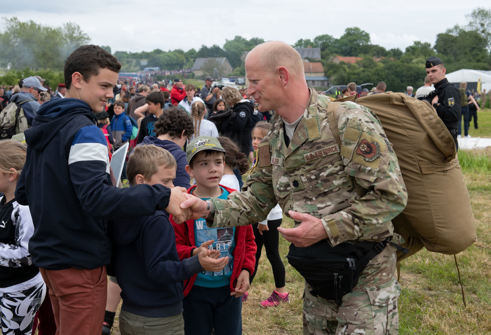 U.S. Air Force Lt. Col. Jake Miller, 752nd Special Operations Group deputy commander, greets local children at the D-Day 75 Commemorative Airborne Operation in Sainte-Mere-Eglise, France, June 9, 2019. This commemorative airborne operation was an opportunity for multinational forces to honor the past and simultaneously work to secure the future. Training together in the very same place that trans-Atlantic resolve began 75 years ago demonstrates the partnerships and bonds that we highly value and continue to benefit from to this day. (U.S. Air Force photo by Airman 1st Class Jennifer Zima)