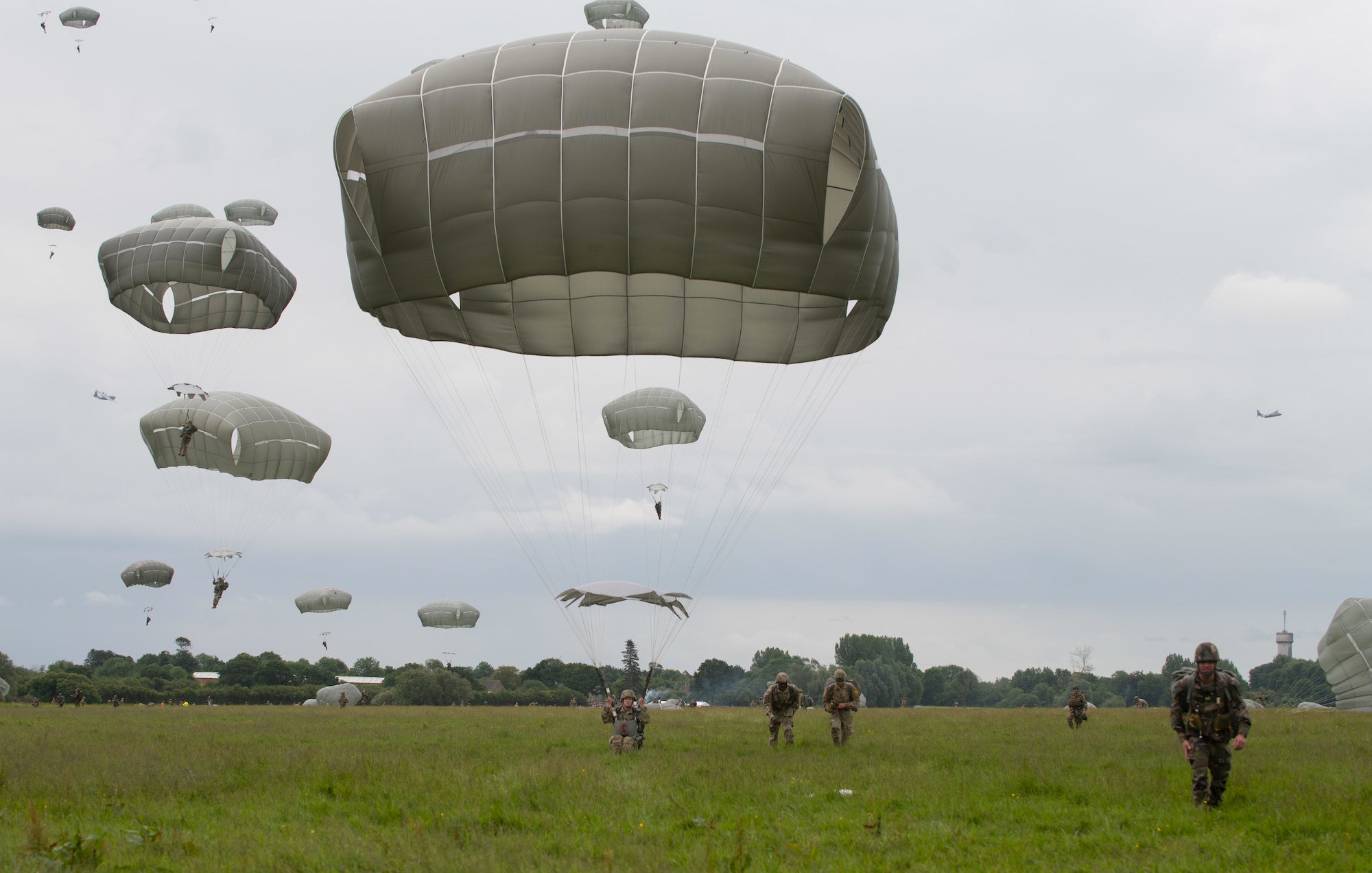 More than 1,100 parachutes sailed above Sainte-Mere-Eglise, France, to commemorate the 75th Anniversary of D-Day June 9, 2019. Nineteen aircraft from multiple nations and parachute jumpers from Belgium, France, Germany, the Netherlands, Romania, United Kingdom and the United States dropped civilians and Soldiers in front of thousands of spectators. (U.S. Air Force photo by Airman 1st Class Jennifer Zima)