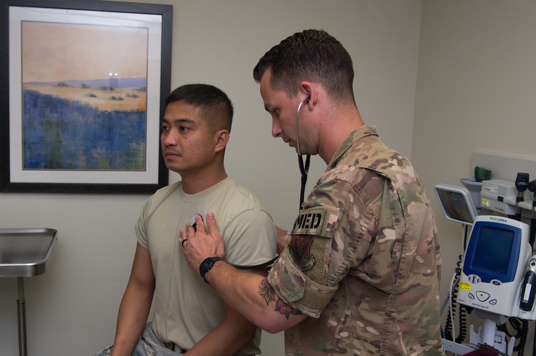 U.S. Air Force Tech. Sgt. James Miller, 633rd Aerospace Medicine Squadron independent duty medical technician, checks the heart rate of Senior Airman Jano Galinada, 633rd AMS health services management technician, at Joint Base Langley-Eustis, Virginia, June 10, 2019.