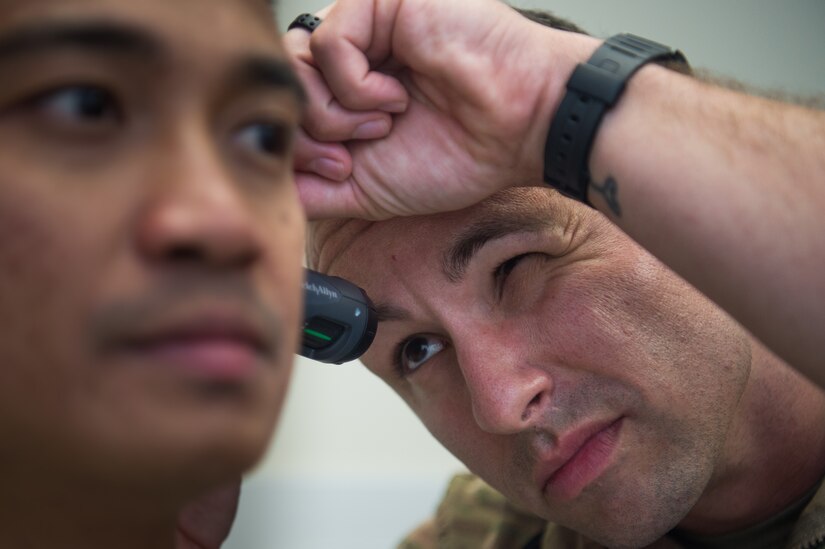 U.S. Air Force Tech. Sgt. James Miller, 633rd Aerospace Medicine Squadron independent duty medical technician, performs a medical exam on Senior Airman Jano Galinada, 633rd AMS health services management technician, at Joint Base Langley-Eustis, Virginia, June 10, 2019.