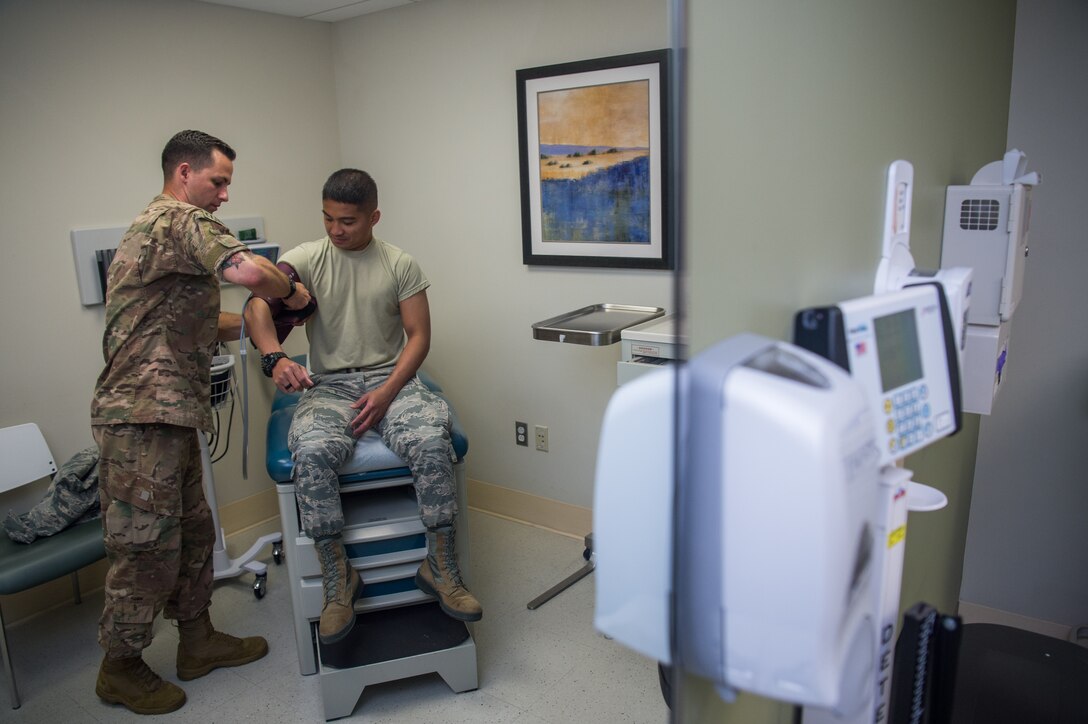 U.S. Air Force Tech. Sgt. James Miller, 633rd Aerospace Medicine Squadron independent duty medical technician, checks the blood pressure of Senior Airman Jano Galinada, 633rd AMS health services management technician, at Joint Base Langley-Eustis, Virginia, June 10, 2019.