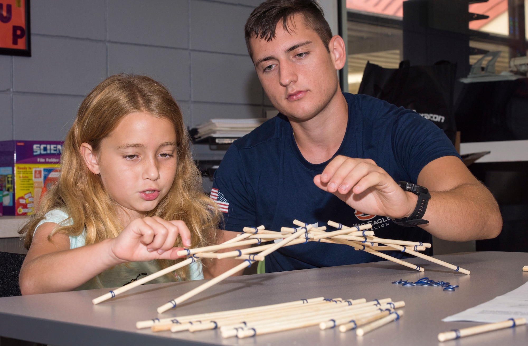 A 6th Force Support Squadron Child Development Center student builds a Da Vinci self-supporting bridge during a science, technology, engineering and mathematics camp at MacDill Air Force Base, Fla., June 11, 2019.