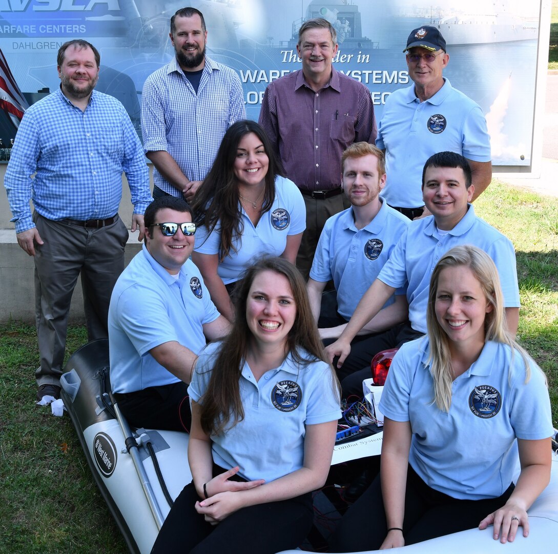 IMAGE: DAHLGREN (June 6, 2019) - The Naval Surface Warfare Center Dahlgren Division (NSWCDD) Sly Fox Mission 25 team and mentors are pictured with a Rigid Hull Inflatable Boat integrated with a hardware representation of PEGASUS – Power and Energy Generation Analysis SimUlation System. The team proved the potential of PEGASUS to integrate electric weapons and electric propulsion systems aboard Navy ships in several demonstrations held at NSWCDD. Left to right in the back row are Sly Fox mentors Thomas Mckelvey, Aaron Albert, Chester Petry, and Tony Scaramozzi. Sly Fox team members in the middle row: Peter Corrao, Marie Zacarias Morro, Joshua Hellerick, and Daniel Apolinar. Sly Fox team members in the front row: Alexa Thomas and Courtney Fredrickson.