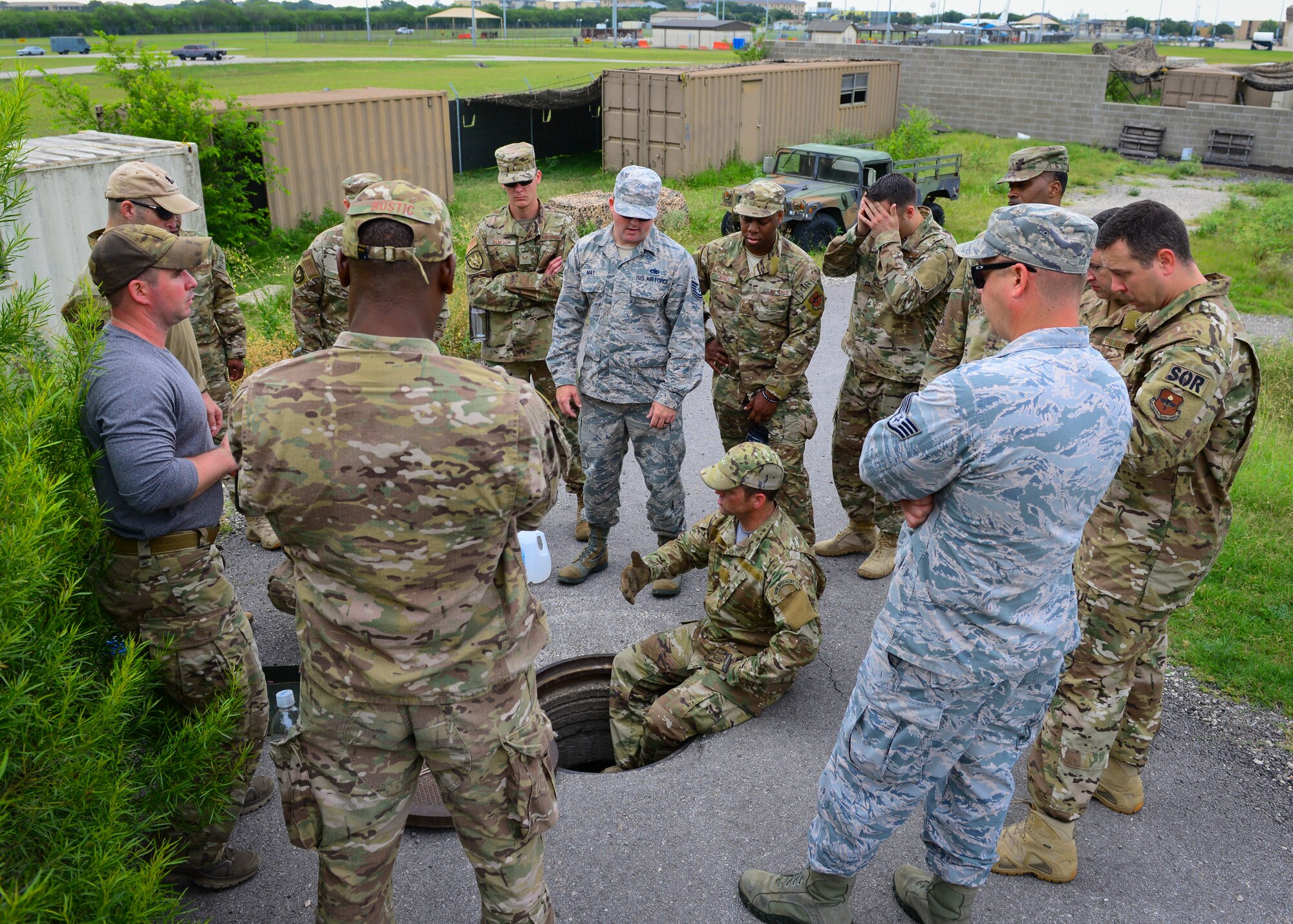 Master Sgt. Travis Mooney, center, cadre member from 66th Training Squadron, Det. 3, at Joint Base San Antonio-Lackland demonstrates how to descend into a manhole, June 3, 2019. Survival, Evasion, Resistance and Escape (SERE) cadre from are responsible for both the four-day Evasion and Conduct After Capture Course and the 15-day SERE Specialist Training Orientation Course at Joint Base San Antonio-Lackland. ECAC was the first stop for recruiters from the 330th RCS who travelled from across the United States to attend this biannual squadron training intended to immerse recruiters into  SERE training in order for them to be better able  to recruit Air Force SERE candidates.