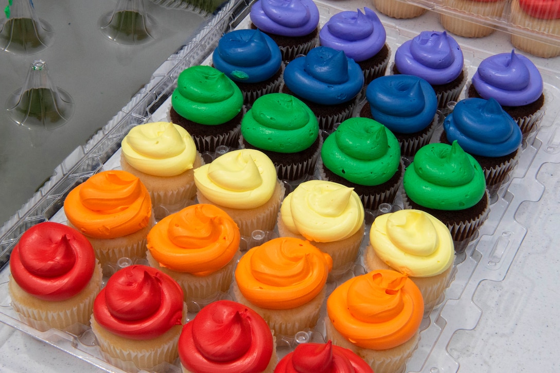 Rainbow cupcakes sit on a tray.