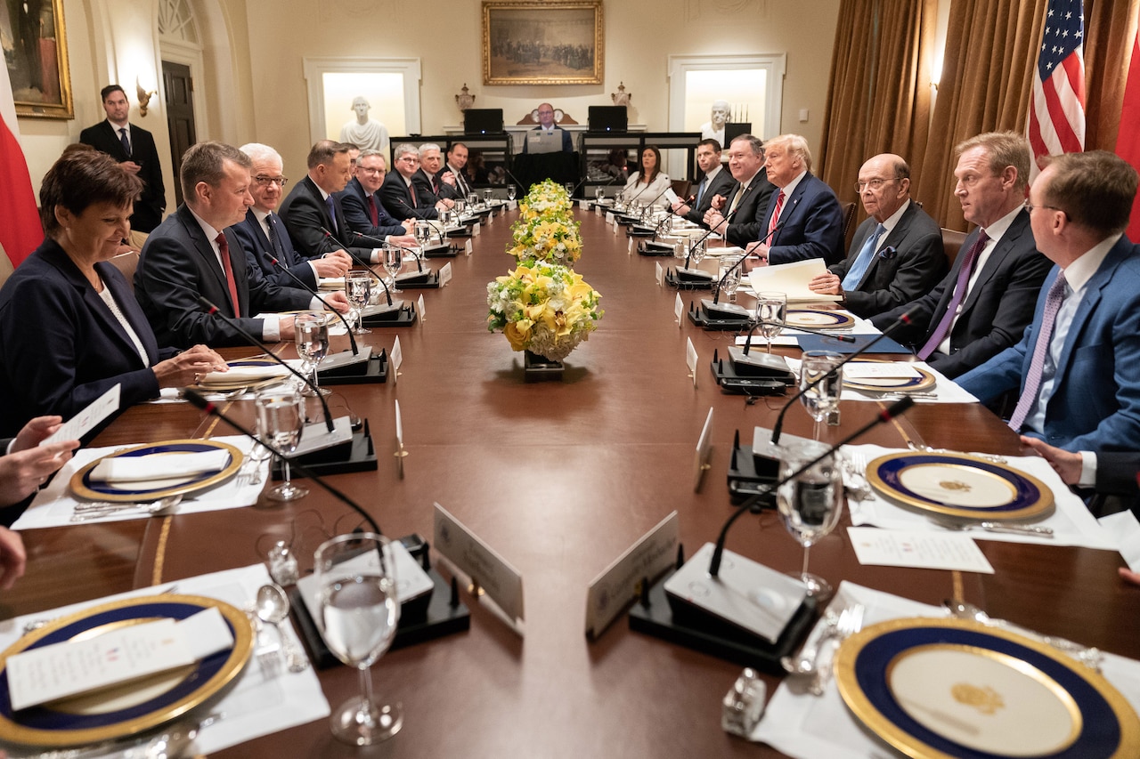 Leaders sit around a long oval table.