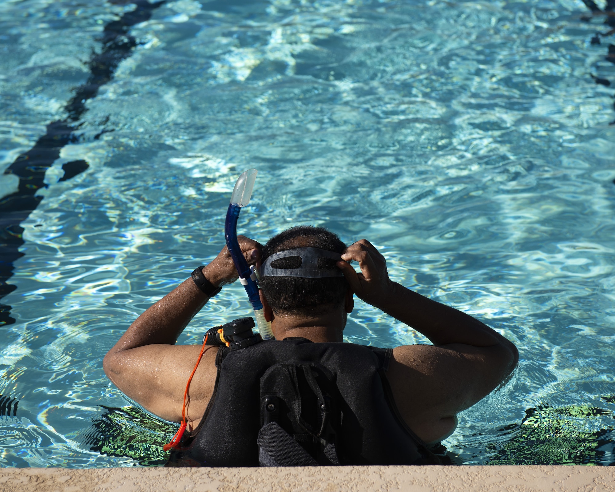 A scuba student puts his goggles and snorkel in place before swimming June 8, 2019, at Luke Air Force Base, Ariz.