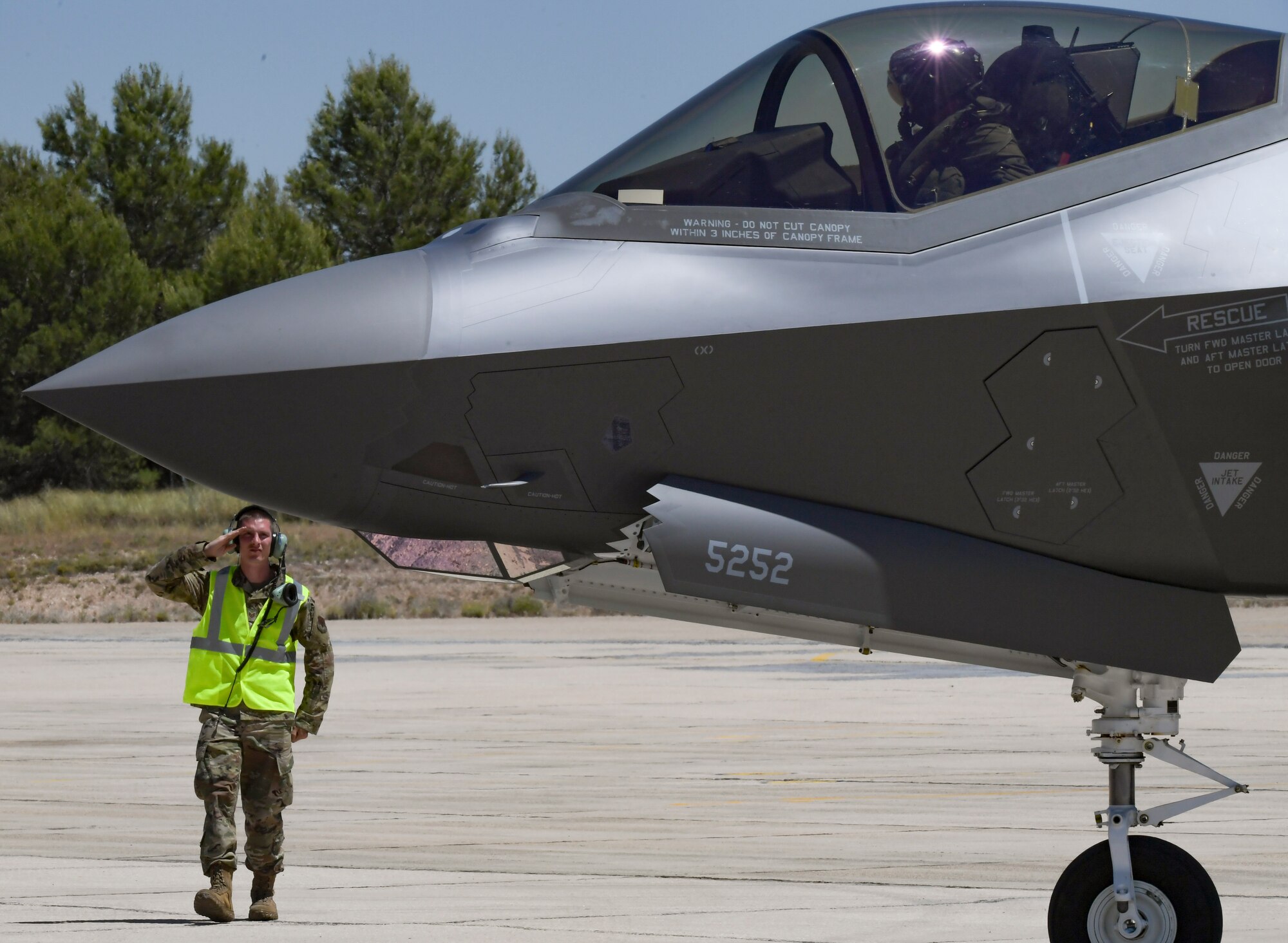 U.S. Air Force Airman salutes F-35A pilot during taxi.