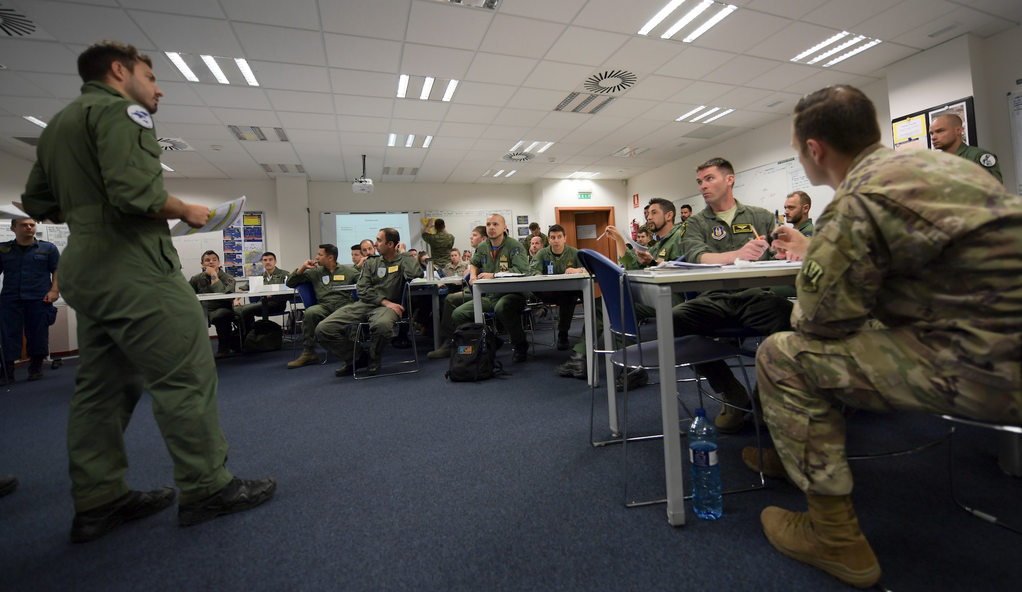 U.S. and NATO pilots review and discuss flight plans during a pre-flight briefing.