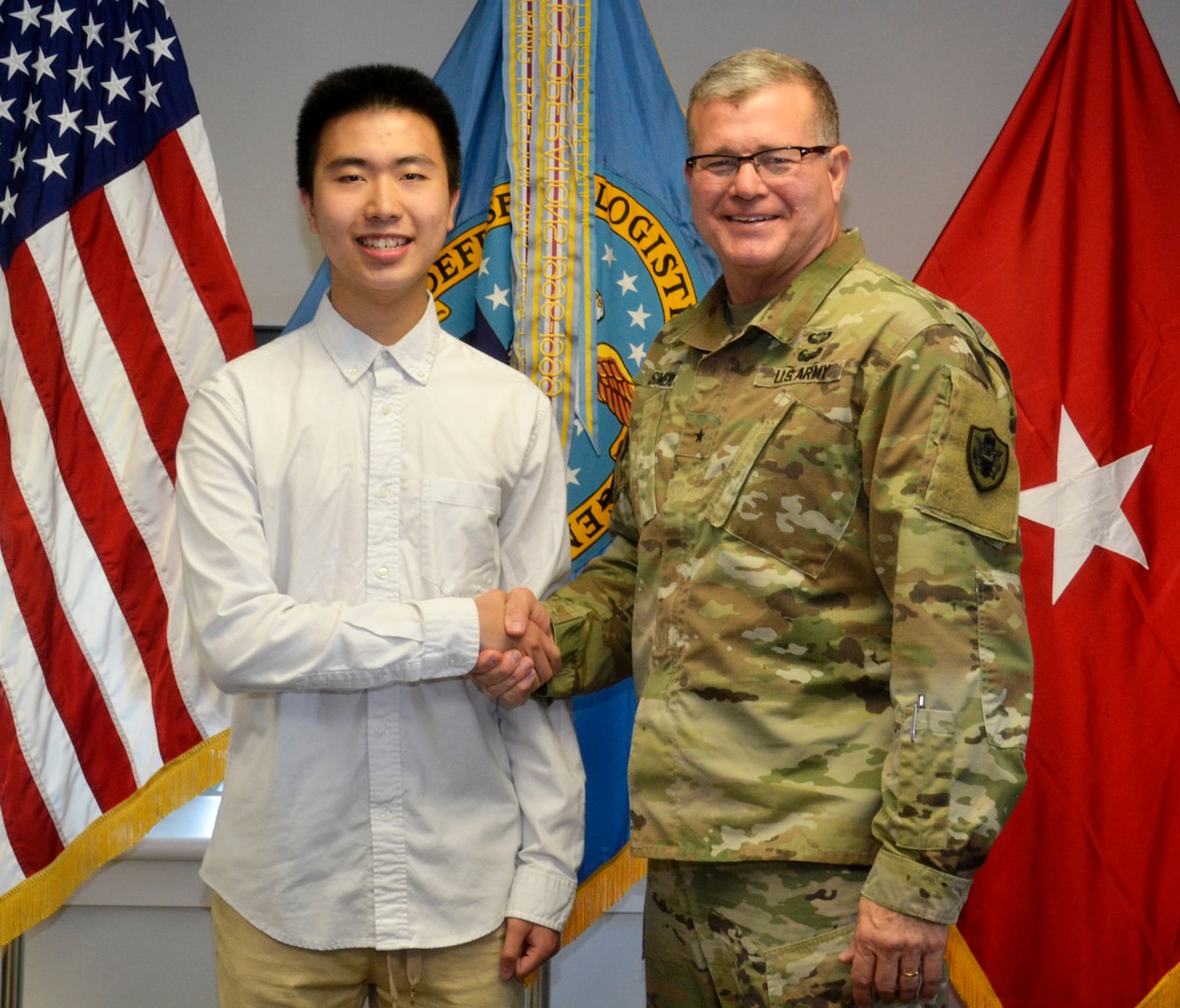 Ning Cao, a former DLA Troop Support intern, left, poses with Army Brig. Gen. Mark Simerly, DLA Troop Support Commander, right, at the DLA Troop Support June 6, 2019 in Philadelphia.