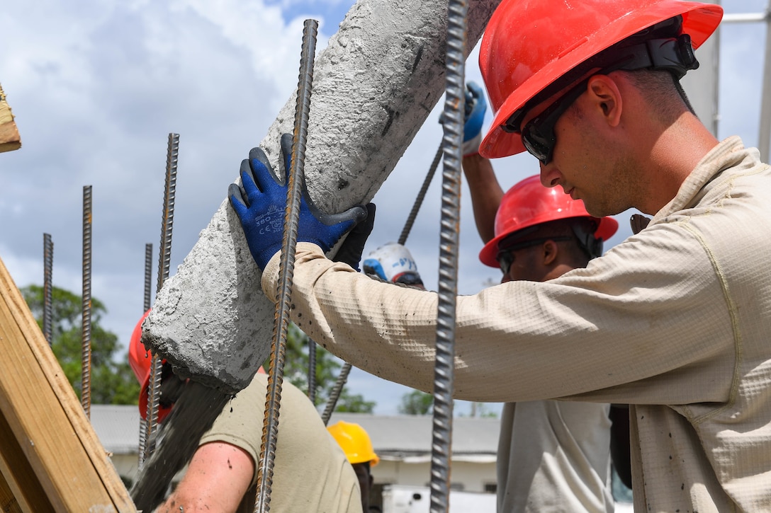 U.S. Air Force Staff Sgt. Joseph Neely, a pavements and equipment operator assigned to the 823rd Red Horse Squadron from Hurlburt Field, Florida directs and controls the concrete pouring hose at the Yarrow kabra construction site.