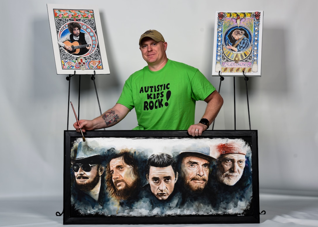 U.S Air Force Tech. Sgt. Isaac Denton, 66th Training Squadron Survival, Evasion, Resistance and Escape specialist, poses with his artwork at Fairchild Air Force Base, Washington, May 29, 2019. Denton has raised over $40,000 selling his paintings and donating the earnings toward raising Autism Awareness. (U.S. Air Force photo by Airman 1st Class Lawrence Sena)