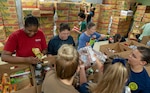 Navy Medicine Education, Training and Logistics Command Sailors sort food during a volunteer community outreach event at the San Antonio Food Bank June 11. The outreach event was part of the Navy’s Sailor 360, a command-level program for junior enlisted, senior enlisted and junior officers, designed to strengthen and develop leadership through outreach events, classroom discussions and physical training.