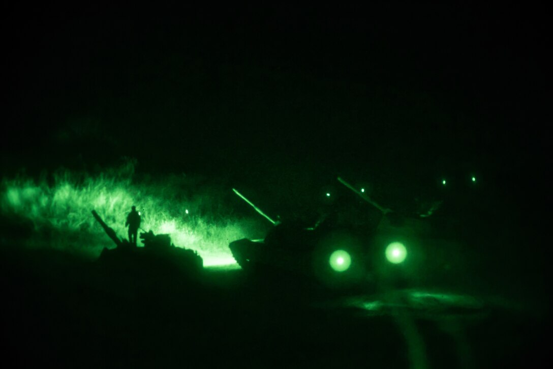 A tank uses green headlights during a night training event.