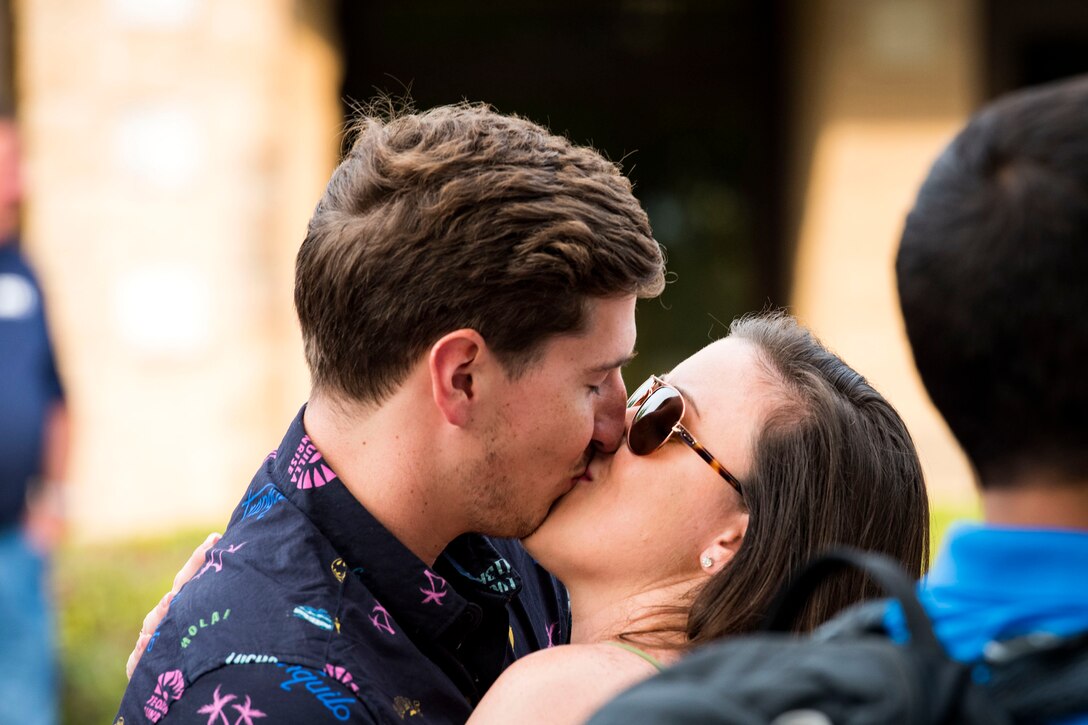 Staff Sgt. Jacob Konopka, left, 38th Rescue Squadron (RQS) combat support squadron aviation resource manager, and Staff Sgt. Natalie Sexton, Special Operations Command Central intelligence analyst, kiss during a redeployment, June 10, 2019, at Moody Air Force Base, Ga. Personnel from the 38th RQS deployed as part of Combined Joint Task Force-Horn of Africa where they provided robust personnel recovery capabilities to support the security objectives of United States Africa Command and United States European Command. (U.S. Air Force photo by Senior Airman Erick Requadt)