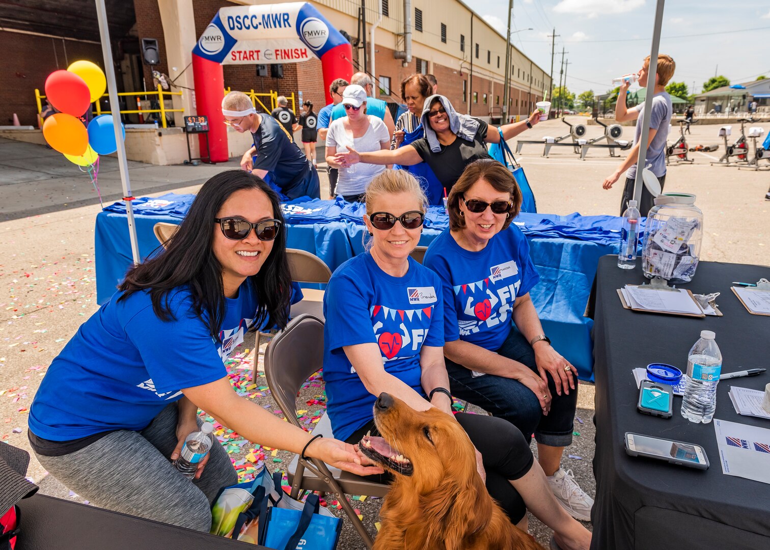 Three women pose for photo with a golden retriever