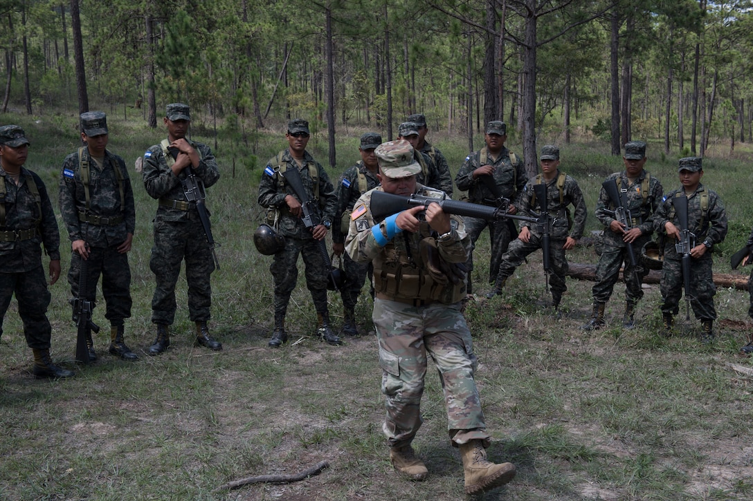 U.S. Army Staff Sgt. Roberto Santini, Puerto Rico National Guard Security Forces Training (SFT) instructor, demonstrates weapon-handling techniques to a group Honduran soldiers during the SFT course June 8, 2019, at the 1st Artillery Battalion in Zambrano, Honduras. Honduran Army soldiers participated in the two-week SFT course led by U.S. Army Puerto Rico National Guard service members assigned to Task Force ¬¬– Borinqueneer. The course taught them about security techniques and procedures to include formation, breaching, weapons training, casualty care, vehicle searching and tactical control points. The training was hosted as way to strengthen the host nations counter threat ability. (U.S. Air Force photo by Staff Sgt. Eric Summers Jr.)