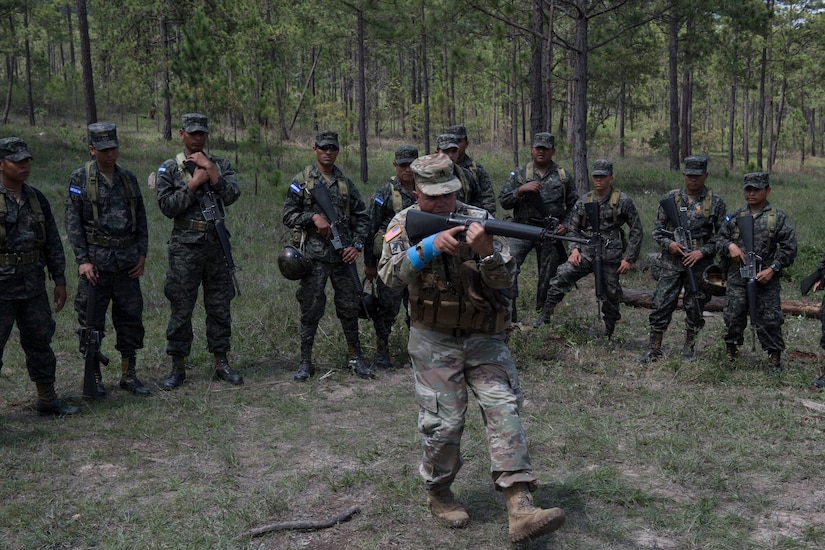 U.S. Army Staff Sgt. Roberto Santini, Puerto Rico National Guard Security Forces Training (SFT) instructor, demonstrates weapon-handling techniques to a group Honduran soldiers during the SFT course June 8, 2019, at the 1st Artillery Battalion in Zambrano, Honduras. Honduran Army soldiers participated in the two-week SFT course led by U.S. Army Puerto Rico National Guard service members assigned to Task Force ¬¬– Borinqueneer. The course taught them about security techniques and procedures to include formation, breaching, weapons training, casualty care, vehicle searching and tactical control points. The training was hosted as way to strengthen the host nations counter threat ability. (U.S. Air Force photo by Staff Sgt. Eric Summers Jr.)