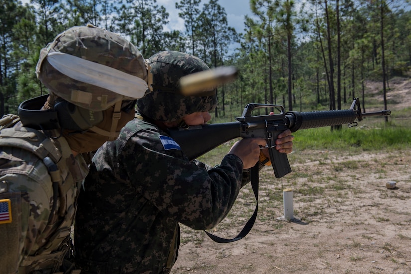 U.S. Army Sgt. Carlos Solver, Puerto Rico National Guard Security Forces Training (SFT) instructor, provides guidance to a Honduran soldier firing an M-16 rifle during the SFT course June 8, 2019, at the 1st Artillery Battalion in Zambrano, Honduras. Honduran Army soldiers participated in the two-week SFT course led by U.S. Army Puerto Rico National Guard service members assigned to Task Force ¬¬– Borinqueneer. The course taught them about security techniques and procedures to include formation, breaching, weapons training, casualty care, vehicle searching and tactical control points. The training was hosted as way to strengthen the host nations counter threat ability. (U.S. Air Force photo by Staff Sgt. Eric Summers Jr.)