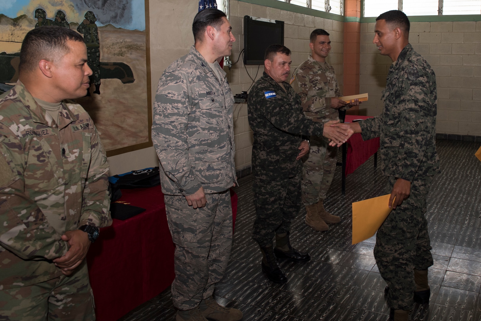 U.S. Army and Honduran military leadership congratulate graduates of the Security Forces Training course June 10, 2019, at the 1st Artillery Battalion in Zambrano, Honduras. Honduran Army soldiers participated in the two-week SFT course led by U.S. Army Puerto Rico National Guard service members assigned to Task Force ¬¬– Borinqueneer. The course taught them about security techniques and procedures to include formation, breaching, weapons training, casualty care, vehicle searching and tactical control points. The training was hosted as way to strengthen the host nations counter threat ability. (U.S. Air Force photo by Staff Sgt. Eric Summers Jr.)