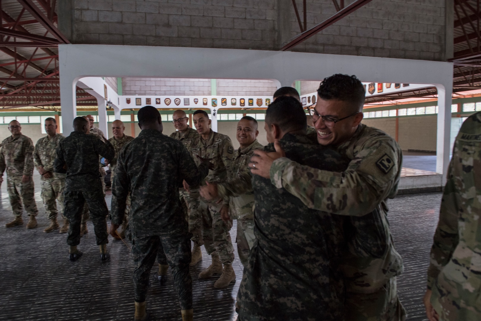 A U.S. Army and Honduran soldier shake hands embrace at the graduation of the Honduran Security Forces Training (SFT) course June 10, 2019, at the 1st Artillery Battalion in Zambrano, Honduras. Honduran Army soldiers participated in the two-week SFT course led by U.S. Army Puerto Rico National Guard service members assigned to Task Force ¬¬– Borinqueneer. The course taught them about security techniques and procedures to include formation, breaching, weapons training, casualty care, vehicle searching and tactical control points. The training was hosted as way to strengthen the host nations counter threat ability. (U.S. Air Force photo by Staff Sgt. Eric Summers Jr.)