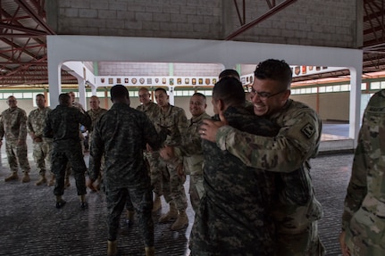 A U.S. Army and Honduran soldier shake hands embrace at the graduation of the Honduran Security Forces Training (SFT) course June 10, 2019, at the 1st Artillery Battalion in Zambrano, Honduras. Honduran Army soldiers participated in the two-week SFT course led by U.S. Army Puerto Rico National Guard service members assigned to Task Force ¬¬– Borinqueneer. The course taught them about security techniques and procedures to include formation, breaching, weapons training, casualty care, vehicle searching and tactical control points. The training was hosted as way to strengthen the host nations counter threat ability. (U.S. Air Force photo by Staff Sgt. Eric Summers Jr.)