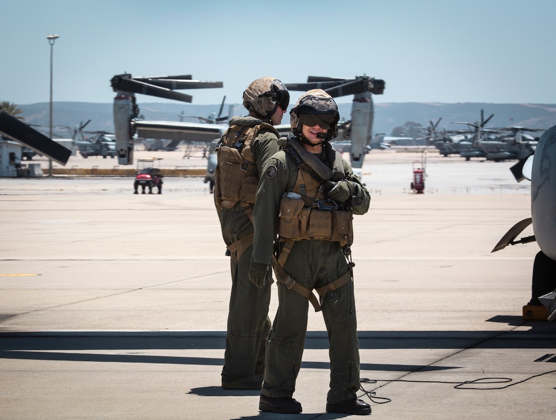 Two crew chiefs with Marine Medium Tiltrotor Squadron (VMM) 764, 4th Marine Aircraft Wing, prepare an MV-22B Osprey on the flight line before taking off from Marine Corps Air Station Miramar, Calif., June 12. Once a year reserve components of the Marine Corps go on two-week annual training detachments to sharpen their skills in their military occupational specialties. (U.S. Marine Corps photo by Sgt. Becky Cleveland)