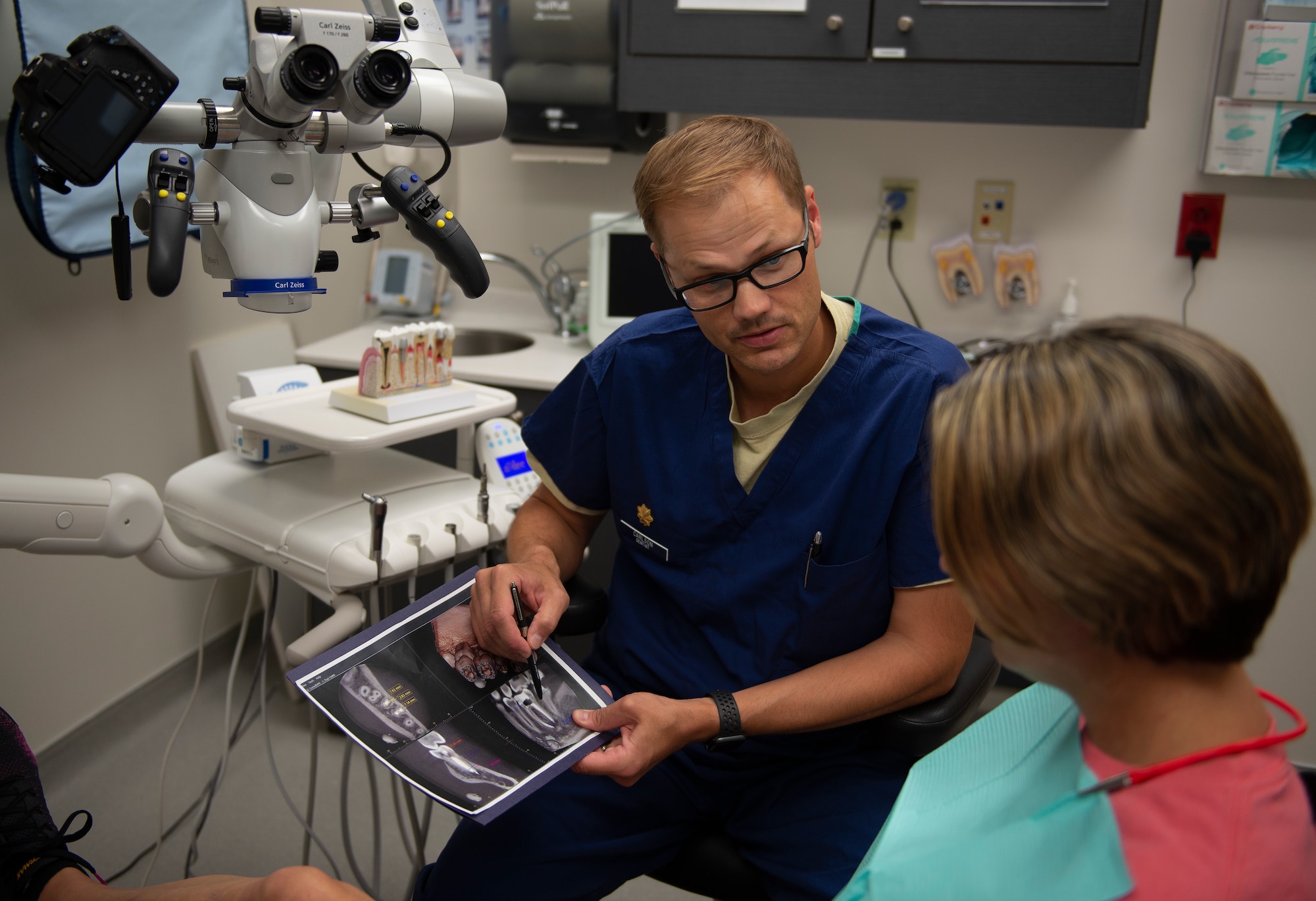 U.S. Air Force Maj. Timothy Carlson, 81st Dental Squadron endodontic resident, explains the root canal procedure to Regina Yarbrough, patient, in the Keesler Dental Clinic here, June 11, 2019. Carlson ensures his patient understands the procedure as well as other options, so they may make an informed decision. (U.S Air Force photo by Airman 1st Class Kimberly Mueller)