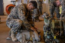 U.S. Marine Corps Lance Cpl. Johnathon Arreola prepares his parachute for a static line jump June 6, 2019 on Marine Corps Air Station Futenma, Okinawa, Japan. Air delivery specialists with Air Delivery Platoon, Landing Support Company, 3rd Transportation Support Battalion, Combat Logistics Regiment 3, 3rd Marine Logistics Group, employed the Joint Precision Airdrop System to enhance mission readiness by providing hands-on rehearsals. The JPADS is an autonomous system designed to provide accurate delivery of cargo and supplies to ground component forces. Arreola, an air delivery specialist with Air Delivery Plt., LS Co., 3rd TSB, CLR-3, 3rd MLG, is a native of Myrtle Beach, South Carolina. (U.S. Marine Corps photo by Lance Cpl. Mark Fike)