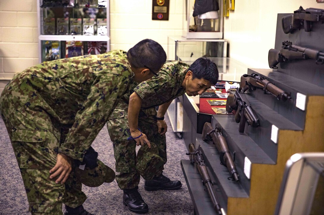 Japanese Ground Self-Defense Force Soldiers examine World War II era weapons during a community exchange program tour on Camp Kinser, Okinawa, Japan June 7, 2019. During the tour, hosted by Combat Logistics Regiment 35, service members visited the base dining facility, supply management unit, a maintenance shop and the Battle of Okinawa historical display, before taking part in a social at the USO. The purpose of the program is to create bonds and increase operational understanding between the JGSDF and the U.S. Marine Corps. (U.S. Marine Corps photo by Pfc. Courtney A. Robertson)