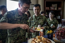Japanese Ground Self-Defense Force Soldiers take part in a meal provided by the USO during a community exchange program tour on Camp Kinser, Okinawa, Japan June 7, 2019. During the tour, hosted by Combat Logistics Regiment 35, service members visited the base dining facility, supply management unit, a maintenance shop and the Battle of Okinawa historical display, before taking part in a social at the USO. The purpose of the program is to create bonds and increase operational understanding between the JGSDF and the U.S. Marine Corps. (U.S. Marine Corps photo by Pfc. Courtney A. Robertson)