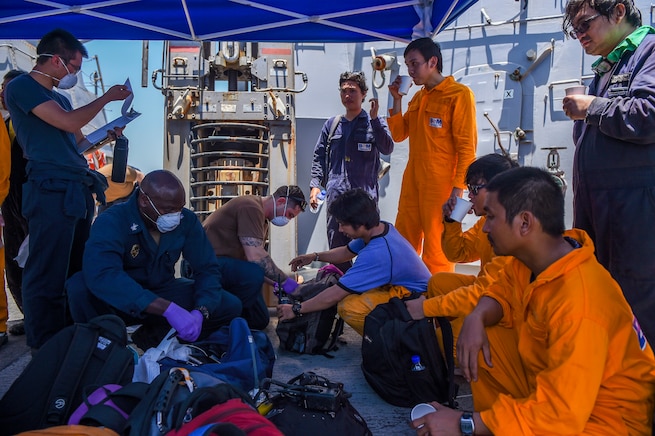 GULF OF OMAN (June 13, 2019) Sailors aboard the Arleigh Burke-class guided-missile destroyer USS Bainbridge (DDG 96) render aid to the crew of the M/V Kokuka Courageous. Bainbridge is deployed to the U.S. 5th Fleet areas of operations in support of naval operations to ensure maritime stability and security in the Central Region, connecting the Mediterranean and Pacific through the Western Indian Ocean and three strategic choke points. (U.S. Navy photo by Mass Communication Specialist 3rd Class Jason Waite/Released)